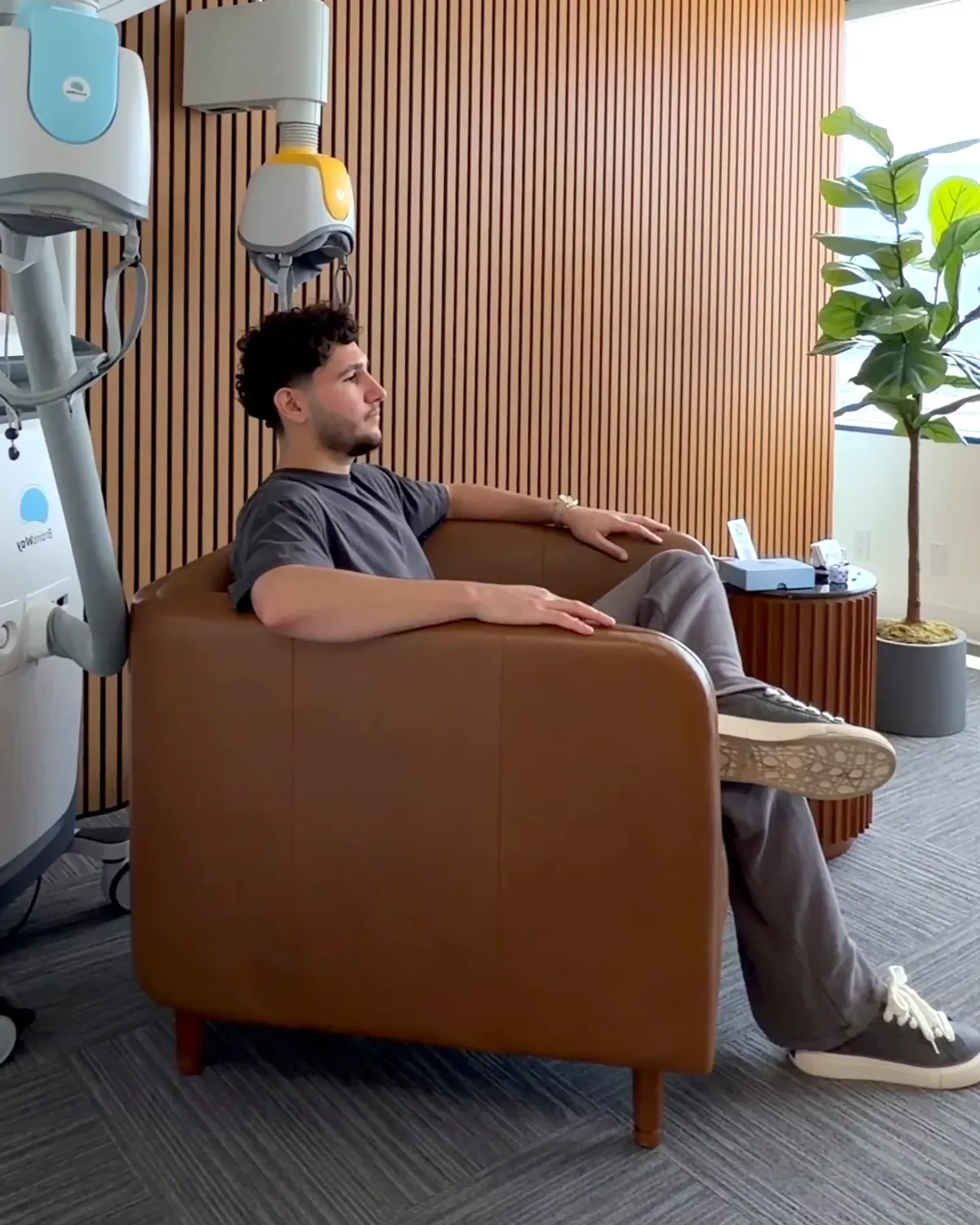 A person seated for Deep TMS in a private treatment room at Breakthrough TMS